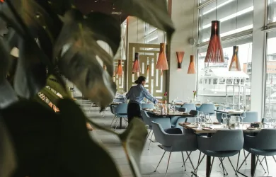 woman in front on brown dining table and chairs inside building