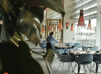 woman in front on brown dining table and chairs inside building